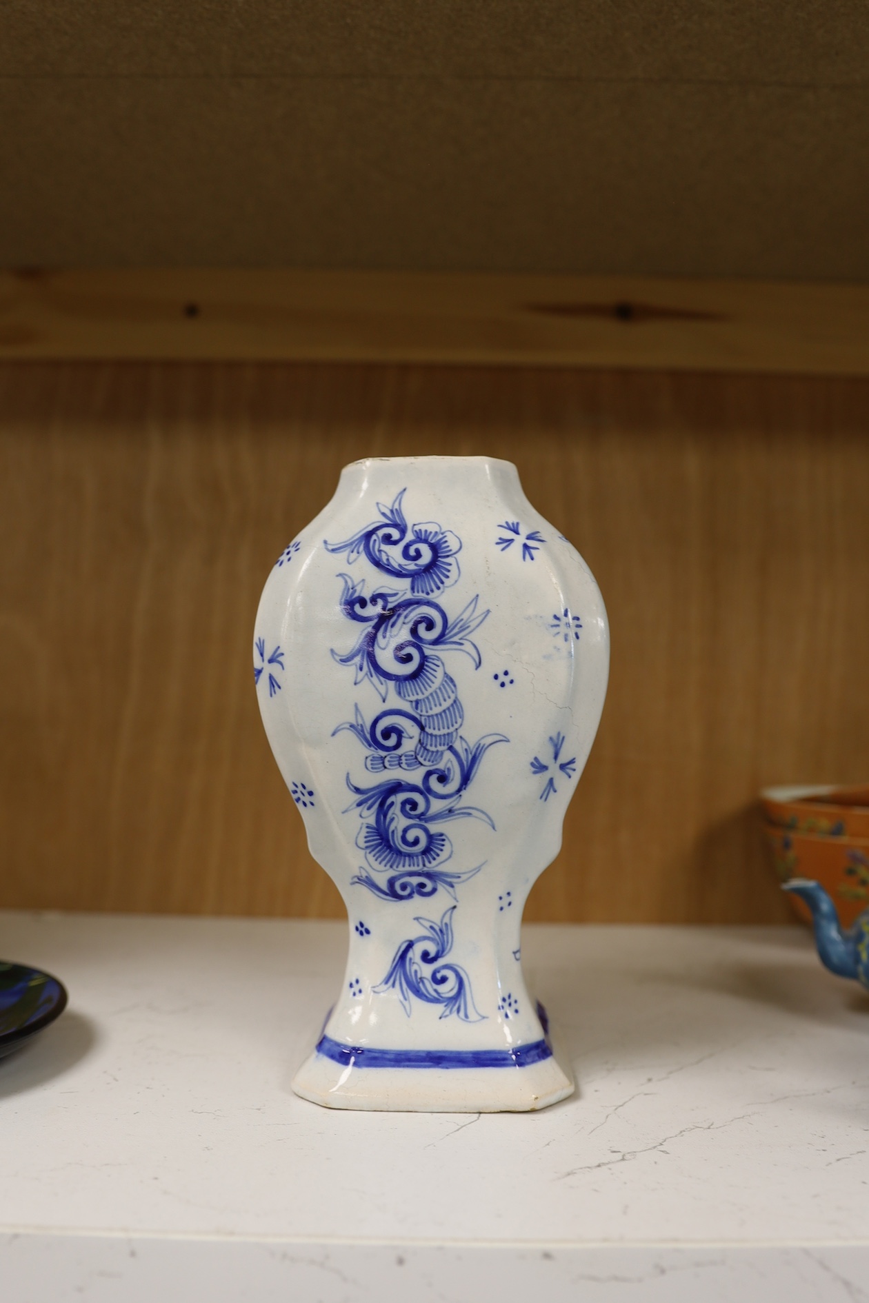 A 19th century Delft blue and white vase and a Watcombe Torquay pottery chamberstick, 19.5cm. Condition - both fair